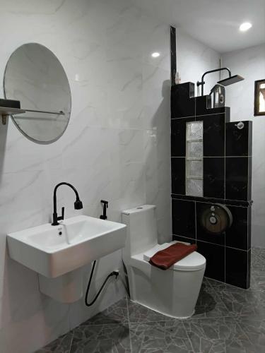 a bathroom with a sink and a toilet and a mirror at Homestay Chiangrai in Chiang Rai