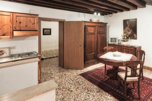 a kitchen with a wooden table and a tableasteryasteryasteryasteryasteryasteryastery at Palazzetto San Lio, Rialto in Venice