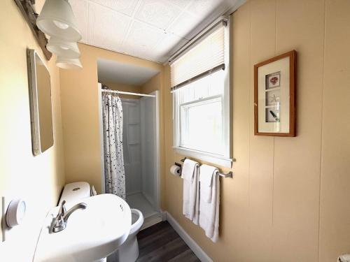 a bathroom with a sink and a toilet and a window at Crosswinds Motel in Old Orchard Beach