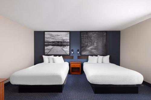 a hotel room with two beds and two windows at Hôtel TERRA Laurentides in Sainte-Agathe-des-Monts