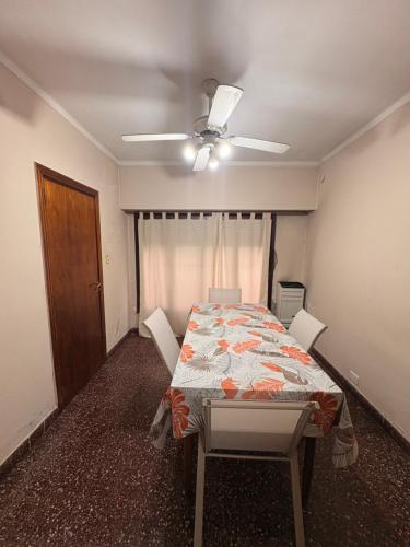 a dining room with a table and a ceiling fan at Casa Encuentro in Pringles