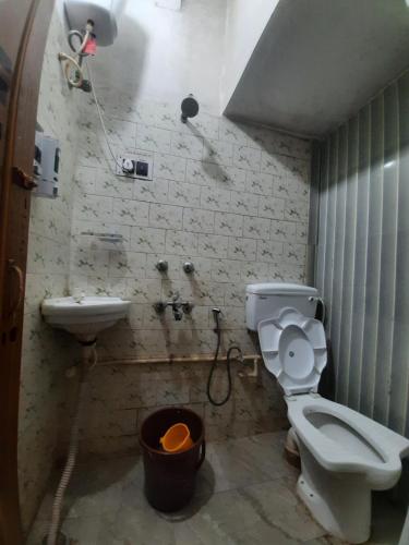 a bathroom with a toilet and a sink at ROAMERS INN Backpackers Hostel in Kolkata