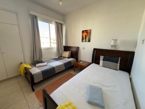 a hotel room with two beds and a window at Central 2 Bedroom Apartment Pafia 2 in Paphos