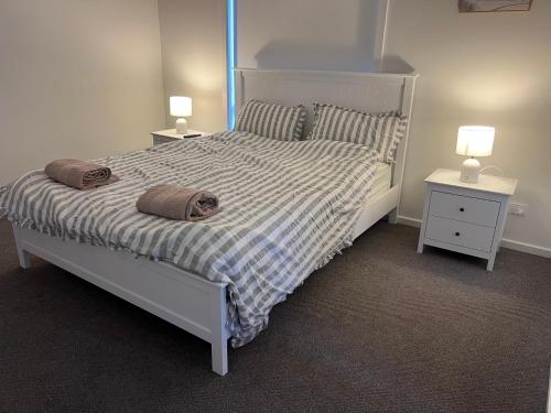 a bedroom with a large bed with two night stands at PONZ Lake Retreat - Nagambie in Nagambie