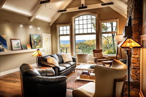 a living room with leather furniture and a large window at Art & Soul in Lyndhurst