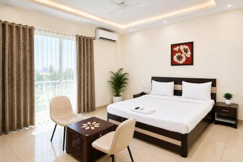 a bedroom with a bed and a table and chairs at Kailashi Hotel Har ki pauri in Haridwār