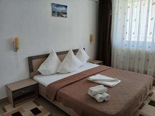 a hotel room with a bed with towels on it at Casa Daniel Borbel in Saturn
