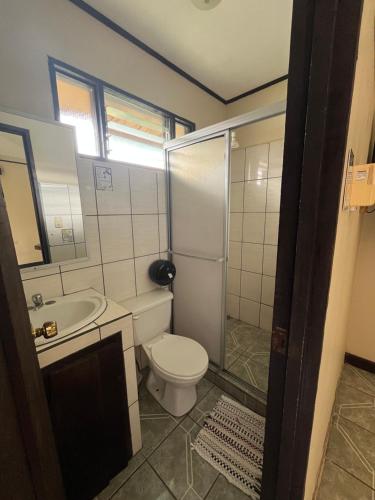 a bathroom with a toilet and a sink and a shower at Hospedaje Las Cabañas in Batán