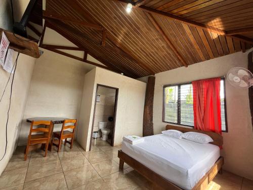 a bedroom with a bed and a table and a desk at Hospedaje Las Cabañas in Batán