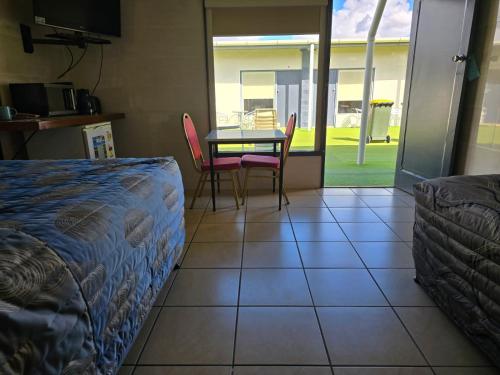 a room with a table and chairs and a table and a bed at Top1Capricorn in The Range
