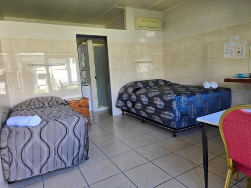 a room with two beds and a table and chairs at Top1Capricorn in The Range