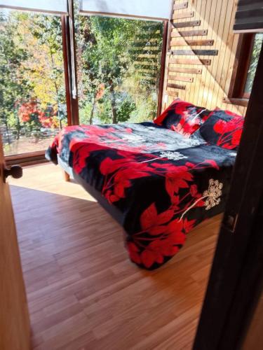 a bed in a room next to a window at Cabañas Alturas Don Gaspar in Recinto