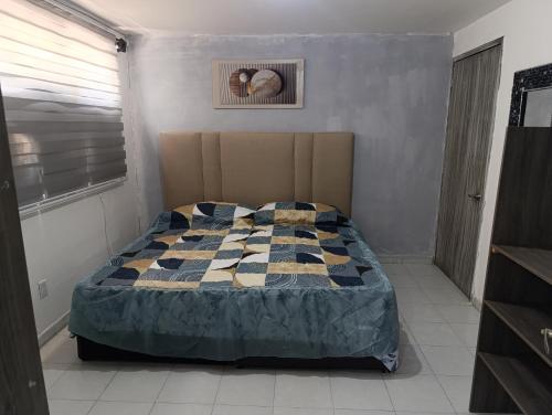 a bedroom with a bed with a quilt on it at Departamento faja de oro in Salamanca