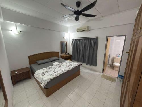 a bedroom with a bed and a ceiling fan at Tiktoki Apartment 15C Kijal in Kijal