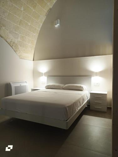a bedroom with a bed with two night stands and two lamps at Radici 1892 in Montescaglioso
