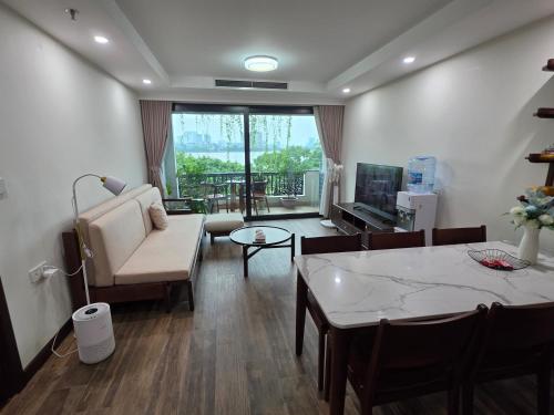 a living room with a table and a dining room at Lakeside Retreat - Tay Ho in Hanoi