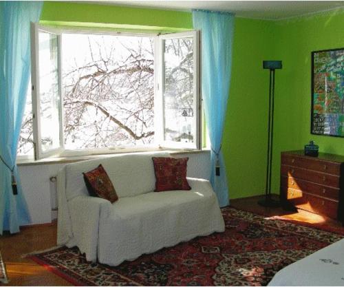 a living room with a white couch in front of a window at Ferienwohnung Guder in Bayerisch Gmain