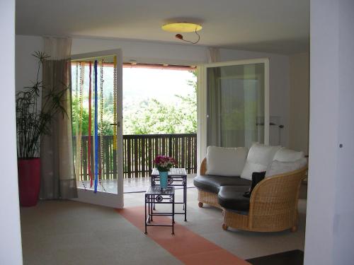 a living room with a couch and a balcony at Ferienwohnung Guder in Bayerisch Gmain