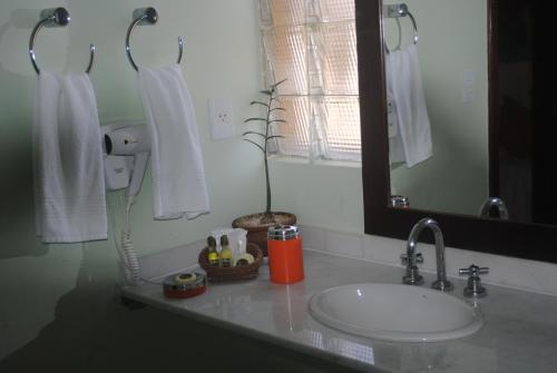 a bathroom counter with a sink and a mirror at Casa Girassois in Pipa