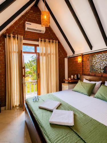 a bedroom with a large bed and a large window at The Oshin Villa in Trincomalee