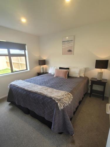 a bedroom with a large bed and a window at Stylish townhouse in Te Aroha