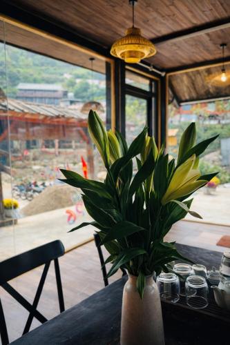 a vase with a plant sitting on a table at Ơ MÂY ZING Homestay in Bắc Yên