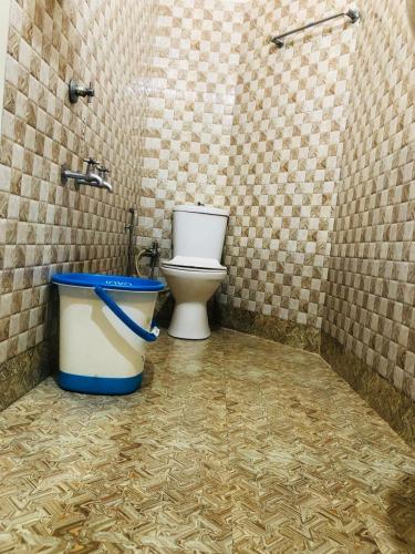 a bathroom with a toilet and a trash can at Sheeba's Homestay in Cochin