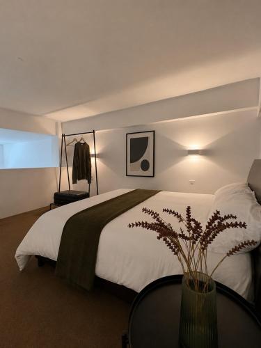 a bedroom with a large white bed with a table at Tailor Urban Loft Thiva in Thiva