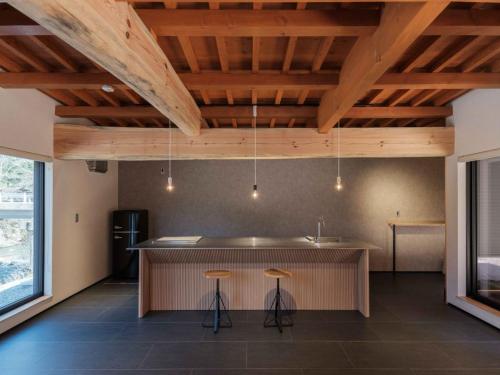 a kitchen with a island in a room with wooden ceilings at 水杜のすみか大野屋 in Fukui