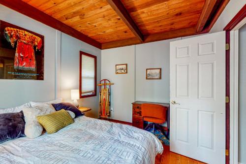 a bedroom with a bed and a desk with a chair at Wooded-View Decks: Family Cabin Retreat in Deming in Warnick