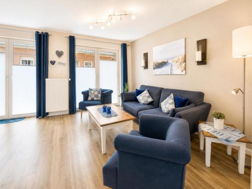 a living room with a blue couch and chairs at Kleine Meereskrabbe in Werdum