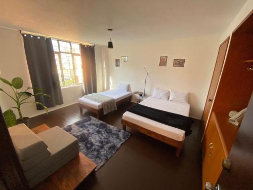 a small room with two beds and a couch at Music Guest House in Mexico City