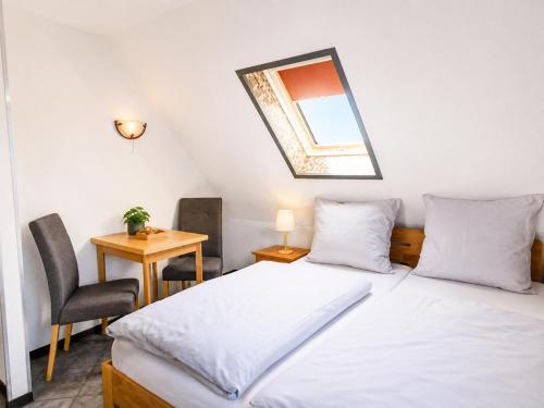 a bedroom with two beds and a table and a mirror at Küstenlounge Dornumersiel in Dornum