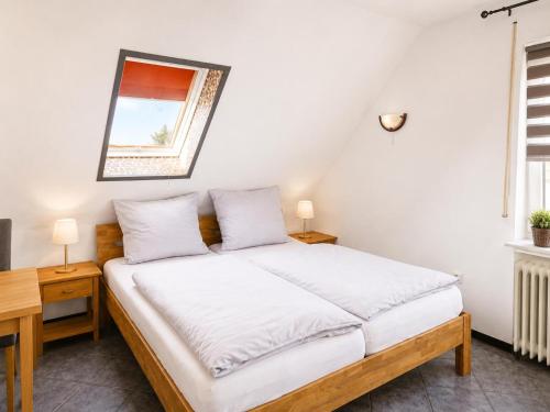 a bedroom with a bed with white sheets and a mirror at Küstenlounge Dornumersiel in Dornum