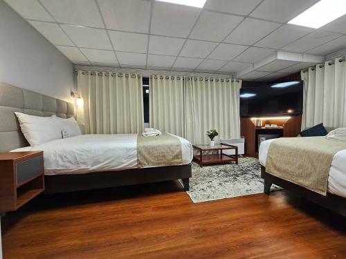 a hotel room with two beds and a table at Casa Hotel Lago Titicaca in Puno