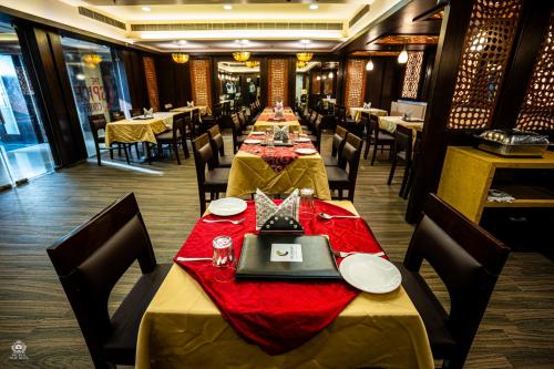 a dining room with long tables with red table cloth at The Crystal Park in Kishangarh