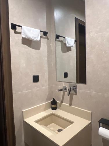 a bathroom with a sink and a mirror and towels at استديو in Al Khobar