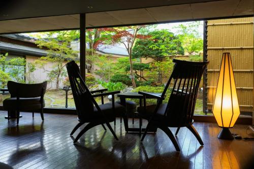 a room with a table and chairs and a lamp at TAOYA Akiu in Sendai