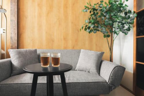 two glasses of beer on a table on a couch at Sand Village Kikuna in Kikuna