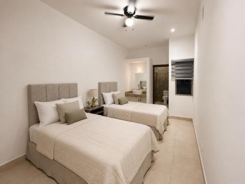 a bedroom with two beds and a ceiling fan at Cumbres Living in Saltillo