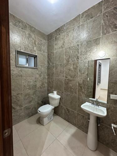 a bathroom with a toilet and a sink at Cumbres Living in Saltillo