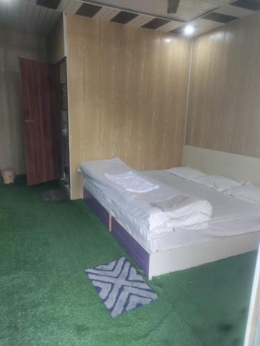 a bed in a room with a green carpet at Inaya resort in Phata
