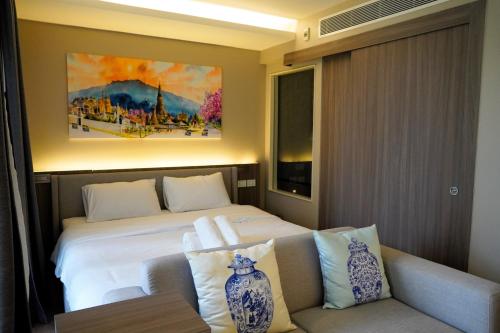 a hotel room with a bed and a couch at Urbitia Thonglor in Klong Toi