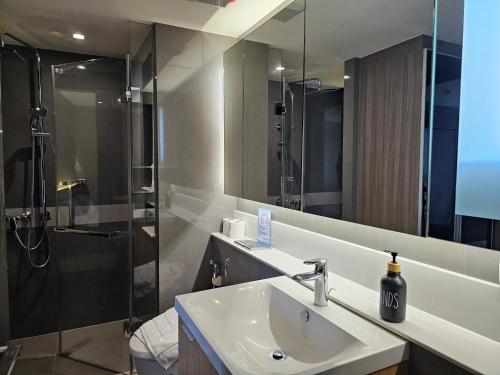 a bathroom with a sink and a shower at Urbitia Thonglor in Klong Toi