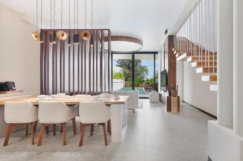 a dining room with a table and white chairs at Balangan Residence in Payangan