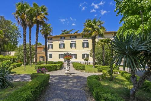 a building with palm trees in front of it at Tenuta Santa Colomba - Happy Rentals in Bientina