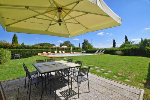 a patio with a table and chairs and an umbrella at Tenuta Santa Colomba - Happy Rentals in Bientina