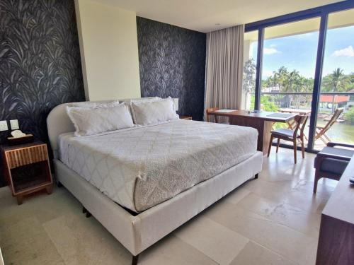 a bedroom with a bed and a desk and a balcony at Escapada romántica- decoración sobre pedido in Nuevo Vallarta
