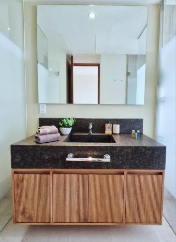 a bathroom with a sink and a large mirror at Escapada romántica- decoración sobre pedido in Nuevo Vallarta