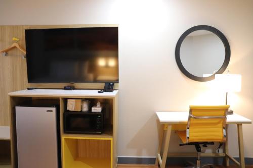 a room with a tv and a desk and a mirror at Days Inn by Wyndham Payson in Payson